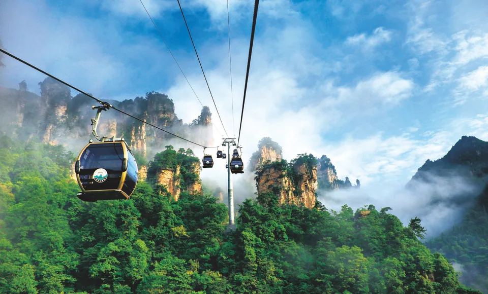 Tianzi Mountain cable-car cabins and sandstone peaks in mist