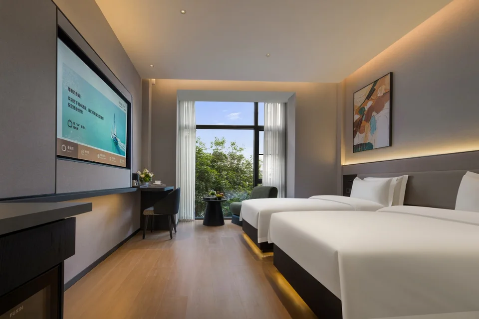 Twin room with a bright window view at Forest Xike Hotel